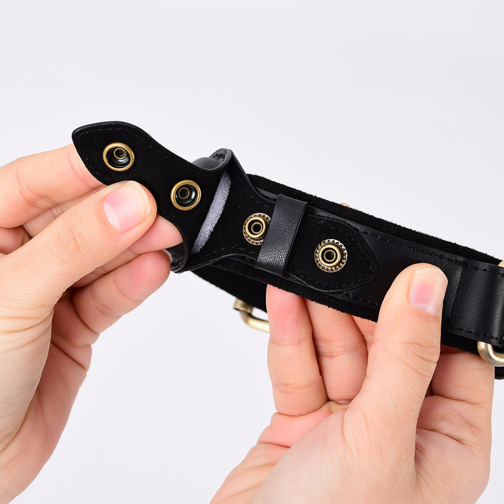 Hands opening the snap-rivet AirTag holder on a black leather dog collar